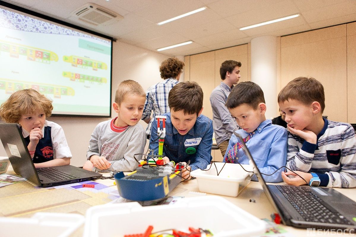 Students gathered around a table working through a hands-on STEM activity