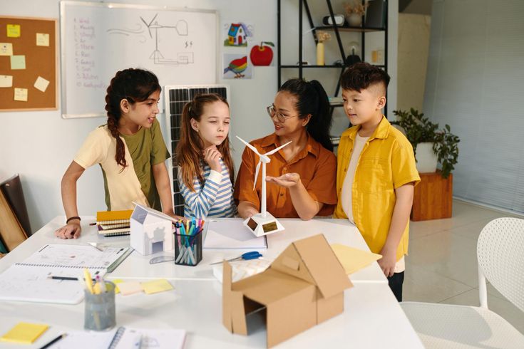 A volunteer guiding students through a hands-on STEM activity