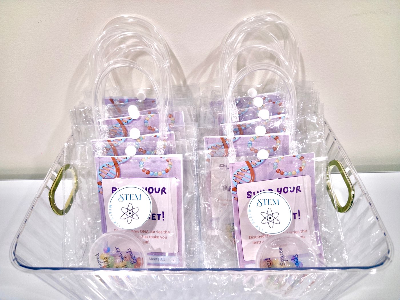 A basket of packaged STEM Meets All DNA bracelet kits